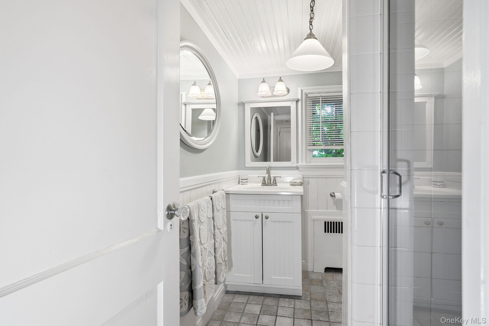 26 Cedarlawn Road Irvington, NY 10533 - Photo 23 of 34 a bathroom with a sink a mirror and a shower