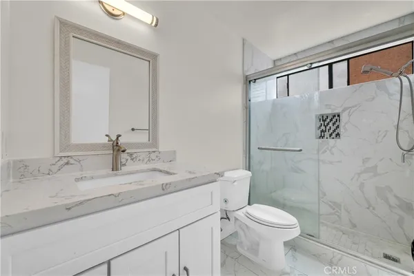 a bathroom with a granite countertop sink toilet and shower
