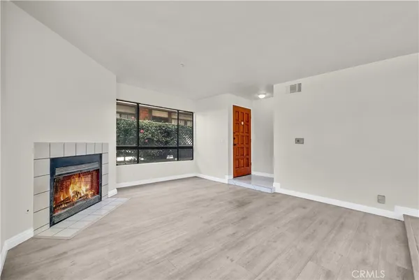 a view of an empty room with a window and fire place