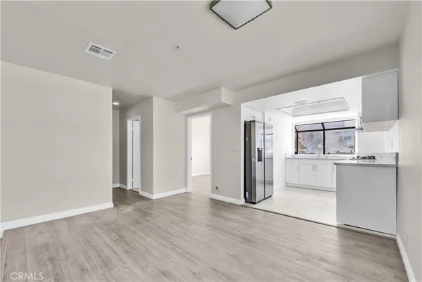 a view of empty room with wooden floor and window