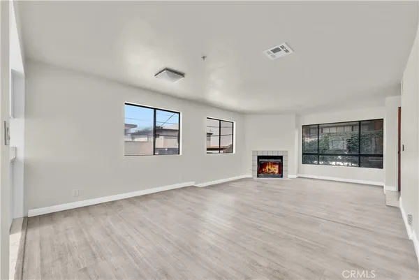 a view of a livingroom with wooden floor and a fireplace