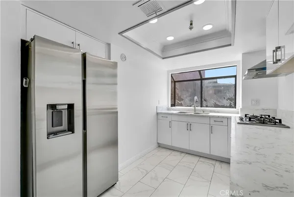a kitchen with a refrigerator sink and cabinets