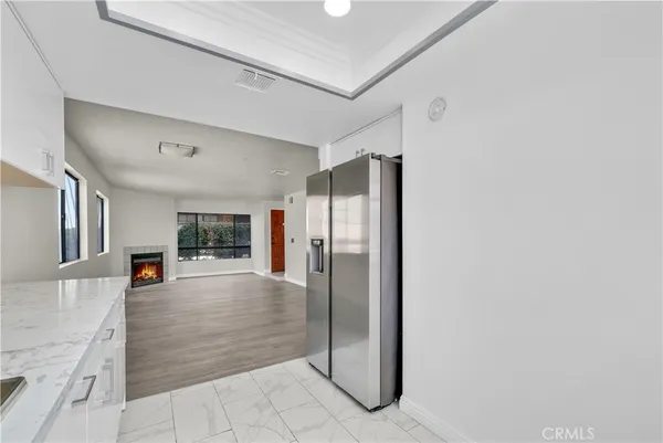 a view of a livingroom with wooden floor and an empty room