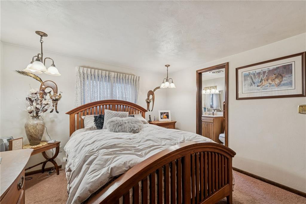 2052 Ridge Road Jeannette, PA 15644 - Photo 20 of 39 a bedroom with a large bed and a chandelier