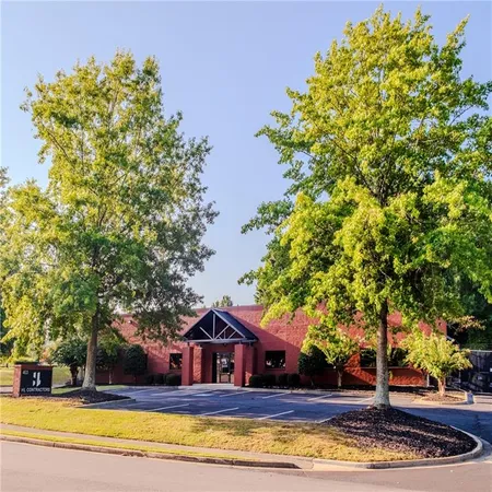 a view of house with yard and trees in the background