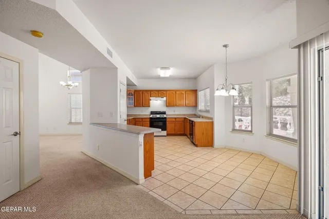 a kitchen with stainless steel appliances kitchen island granite countertop a refrigerator and a sink