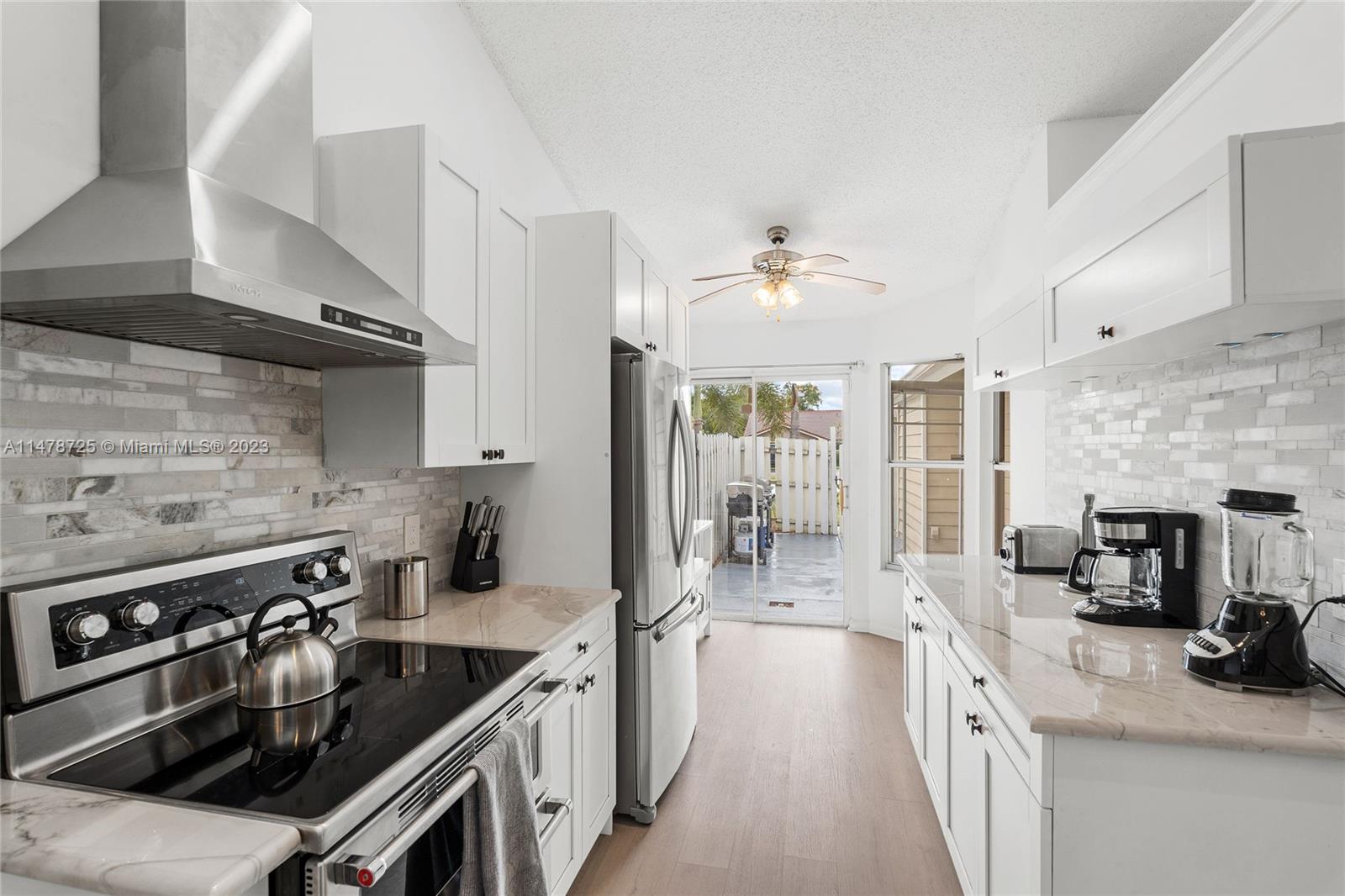 12722 Westhampton Circle Wellington, FL 33414 - Photo 11 of 52 a kitchen with stainless steel appliances granite countertop a sink stove and refrigerator