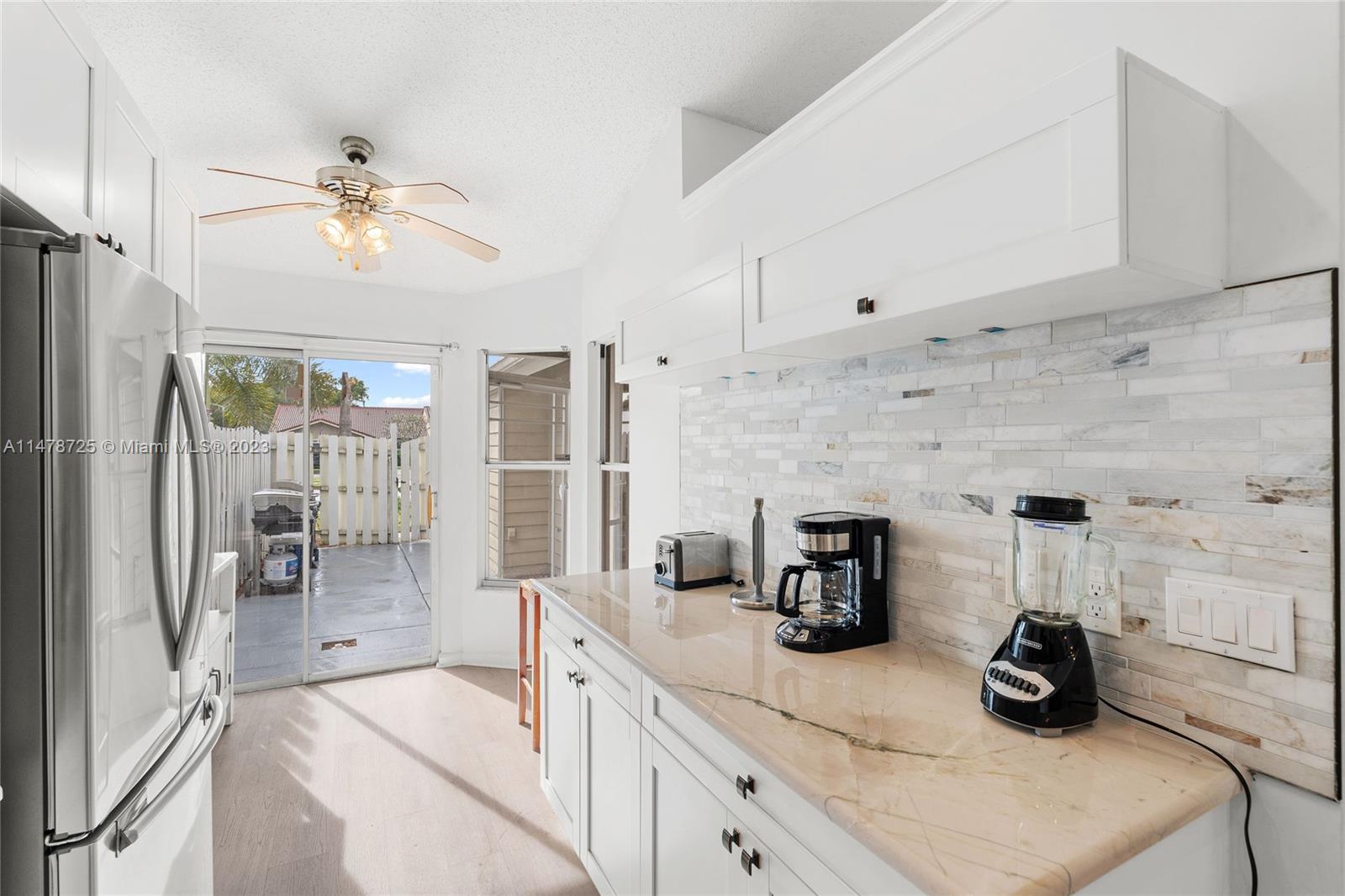 12722 Westhampton Circle Wellington, FL 33414 - Photo 12 of 52 a kitchen with stainless steel appliances white cabinets and a refrigerator