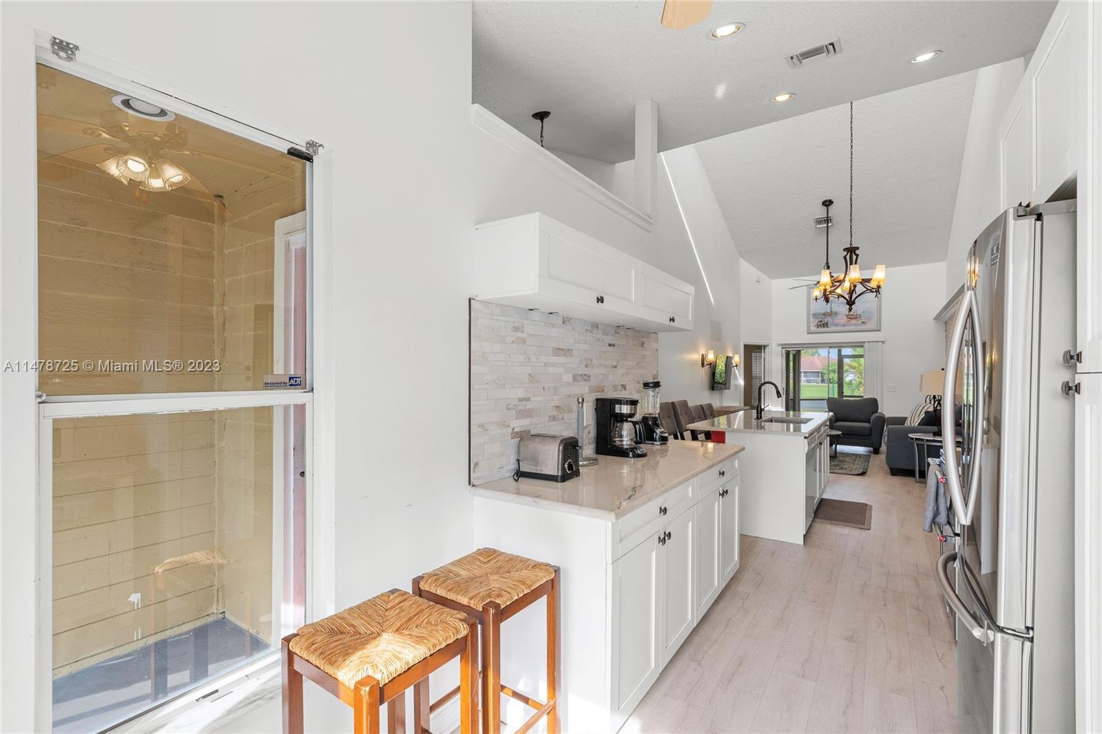12722 Westhampton Circle Wellington, FL 33414 - Photo 14 of 52 a kitchen with stainless steel appliances kitchen island granite countertop a refrigerator and a stove