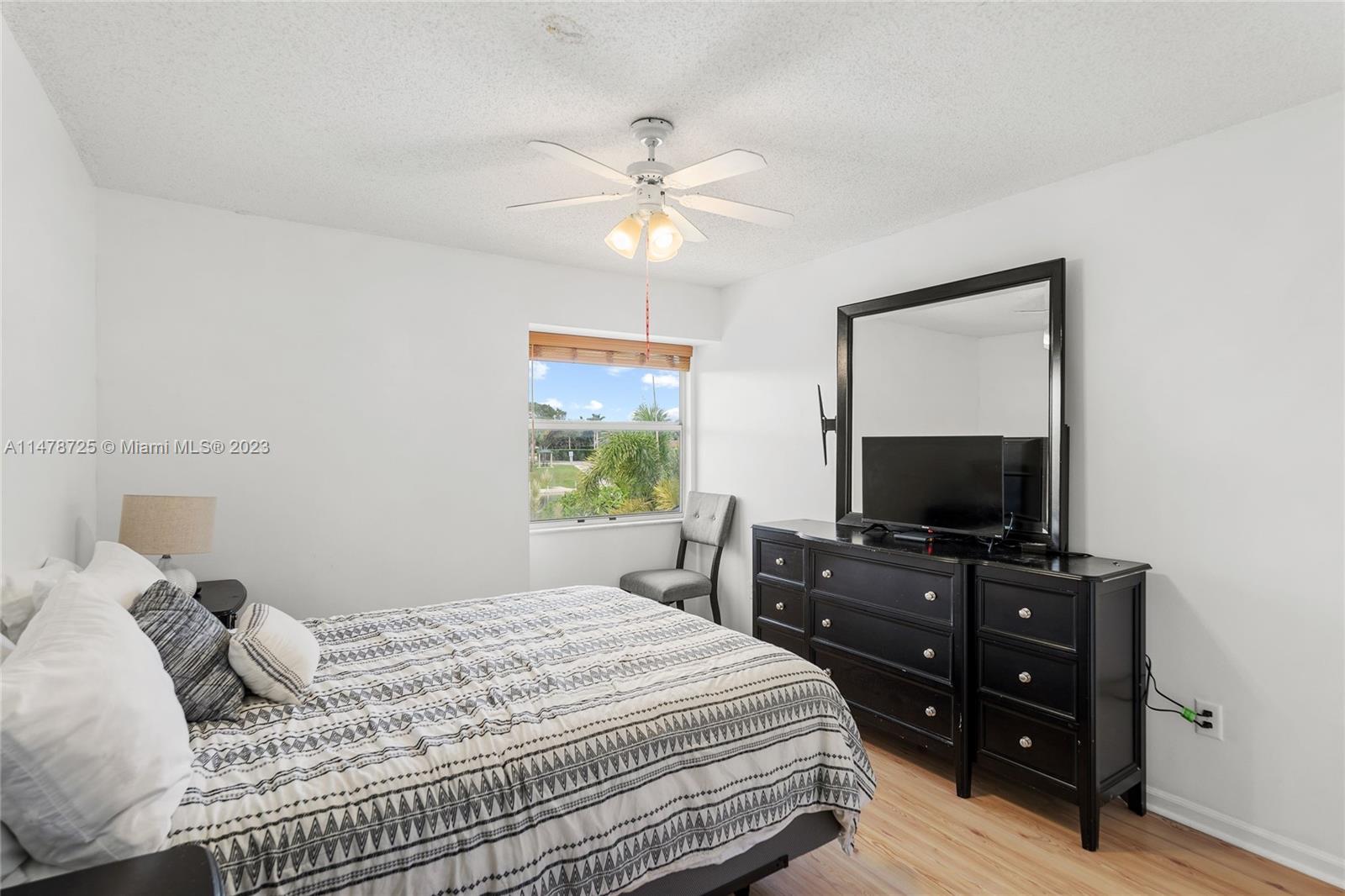 12722 Westhampton Circle Wellington, FL 33414 - Photo 26 of 52 a bedroom with a bed and a flat screen tv