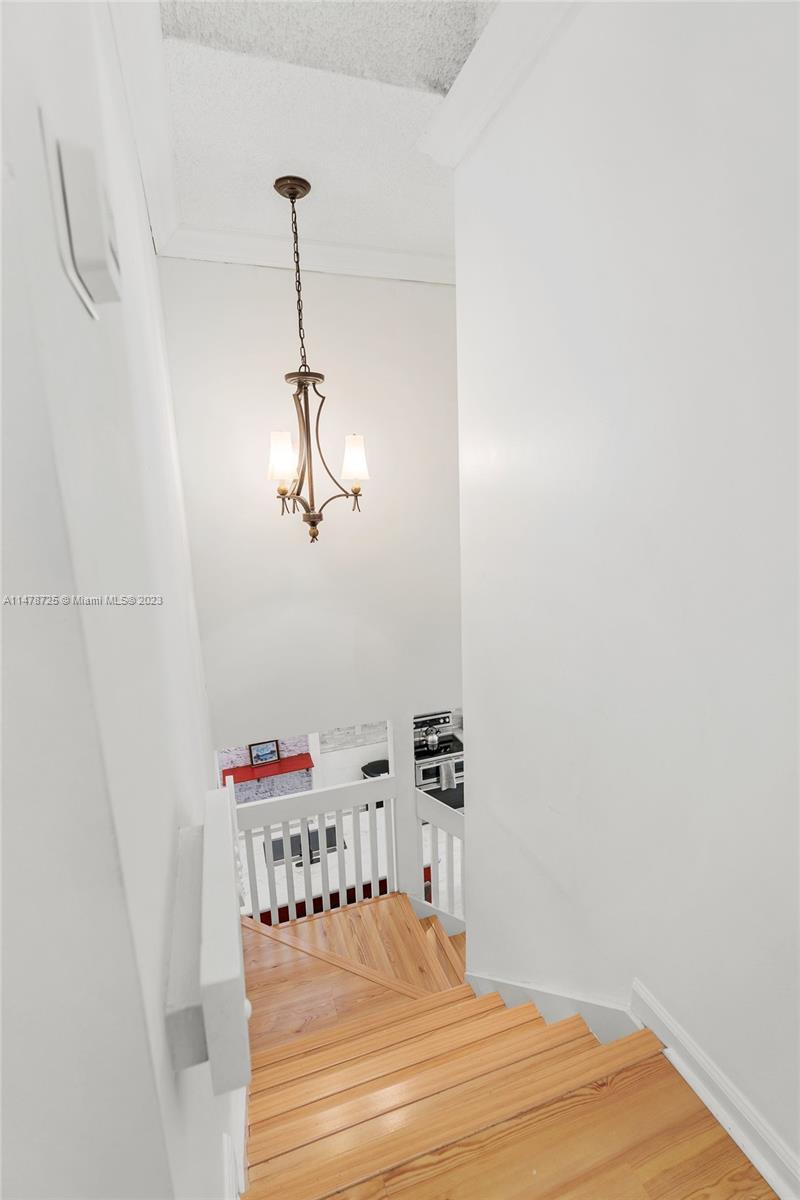 12722 Westhampton Circle Wellington, FL 33414 - Photo 28 of 52 a room with a chandelier fan and wooden floor