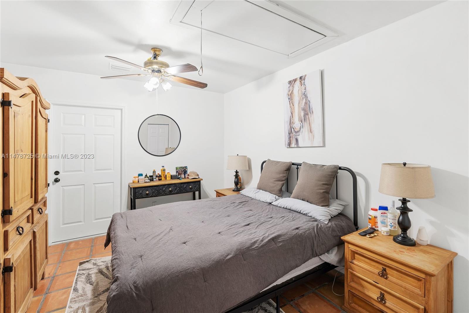 12722 Westhampton Circle Wellington, FL 33414 - Photo 29 of 52 a bedroom with a bed and a chandelier