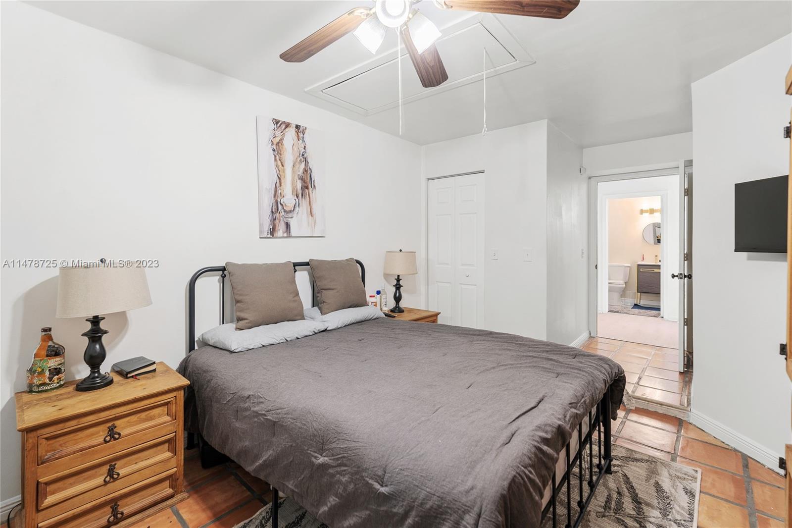 12722 Westhampton Circle Wellington, FL 33414 - Photo 30 of 52 a bedroom with a bed and wooden floor