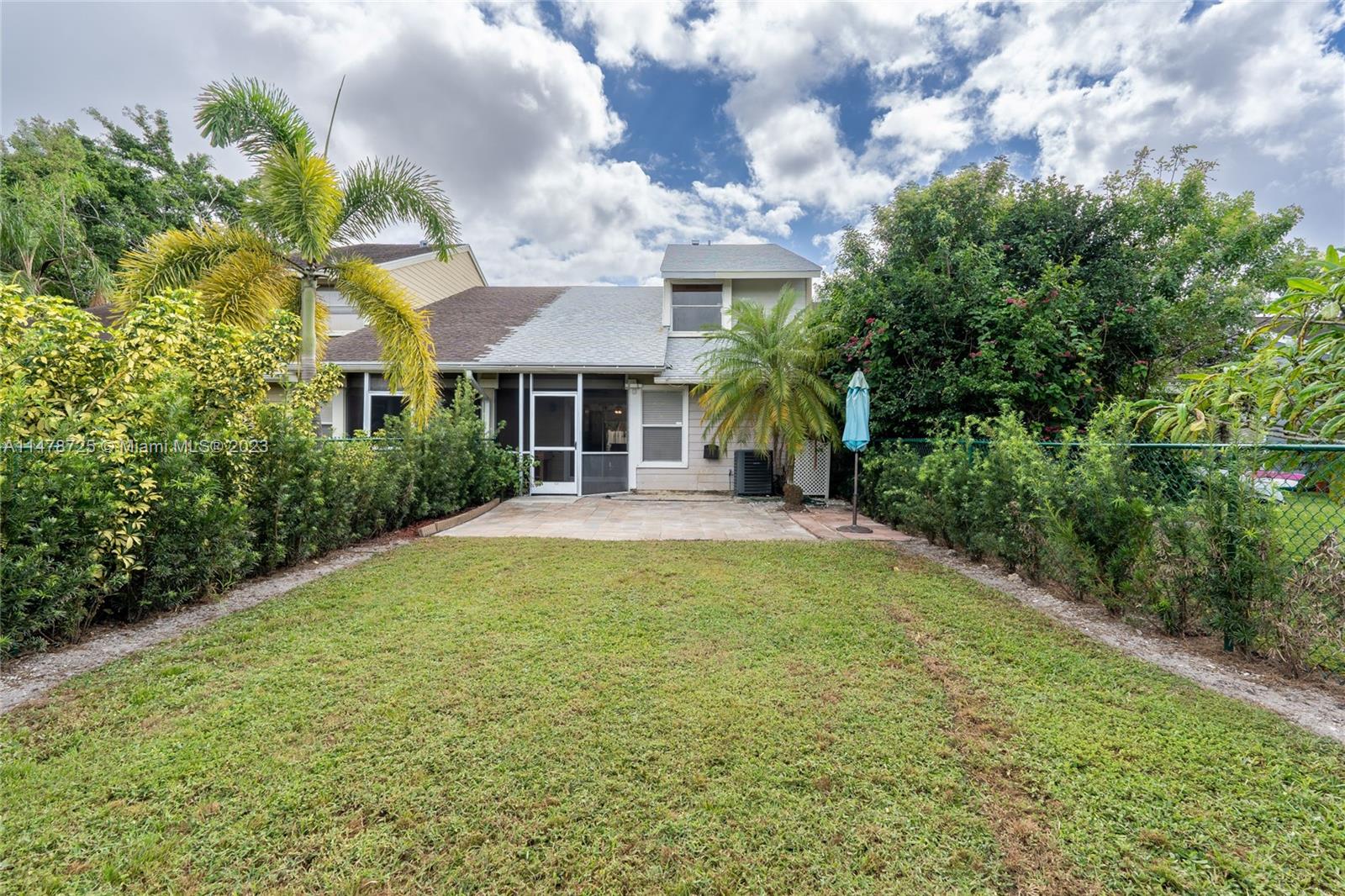 12722 Westhampton Circle Wellington, FL 33414 - Photo 43 of 52 a view of a house with a yard and potted plants