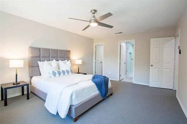 a spacious bedroom with a bed and a ceiling fan