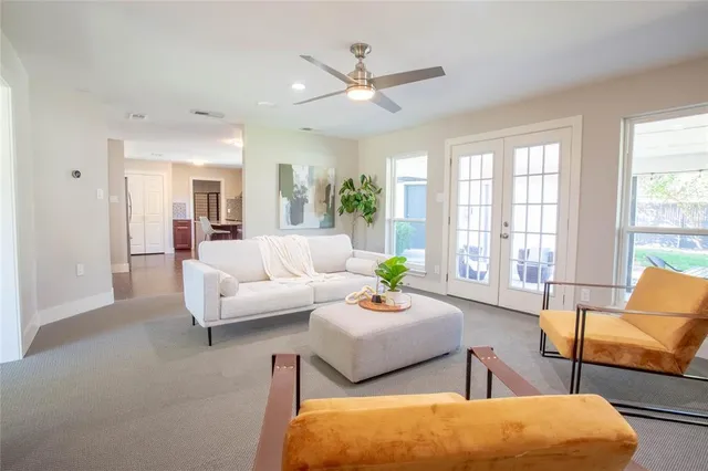 a living room with furniture and a large window with balcony view