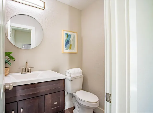 a bathroom with a sink mirror vanity and toilet