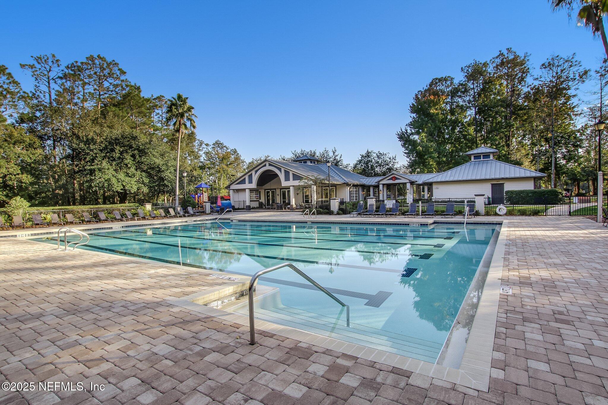 1912 Bluebonnet Way Fleming Island, FL 32003 - Photo 30 of 41 a view of swimming pool that has lawn chairs with plants and palm trees