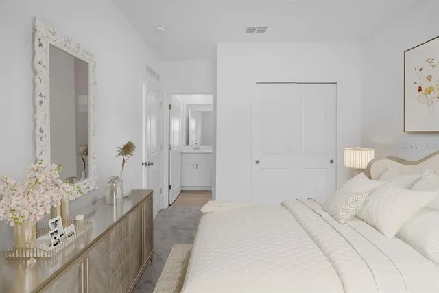 a bedroom with a bed and a lamp with wooden floor