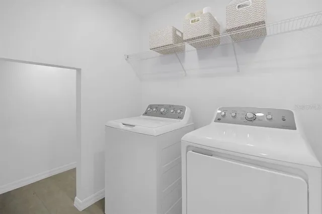 a kitchen with stainless steel appliances granite countertop a refrigerator stove a sink and white cabinets