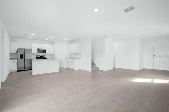 a view of an empty room with a kitchen