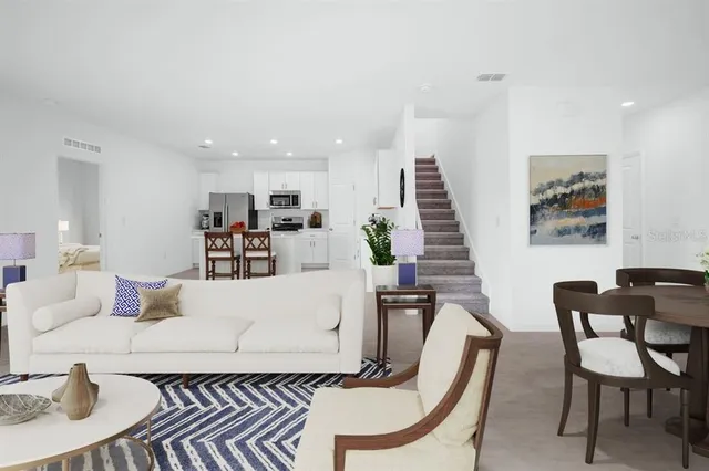 a living room with furniture and kitchen view
