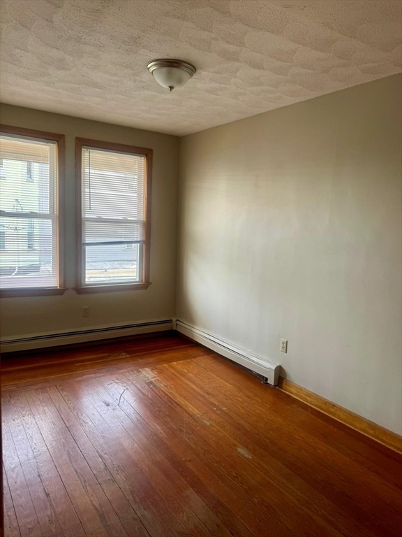 68 Maverick Street Chelsea, MA 02150 - Photo 8 of 16 an empty room with wooden floor and windows