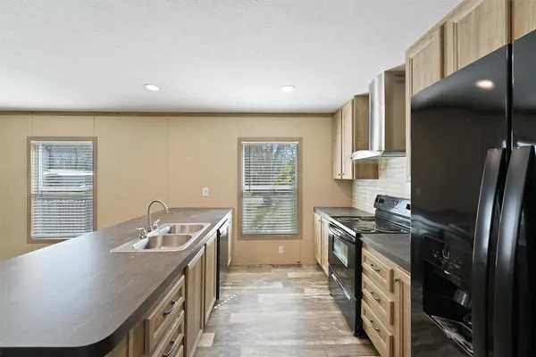 a kitchen with stainless steel appliances granite countertop a sink a stove and a refrigerator