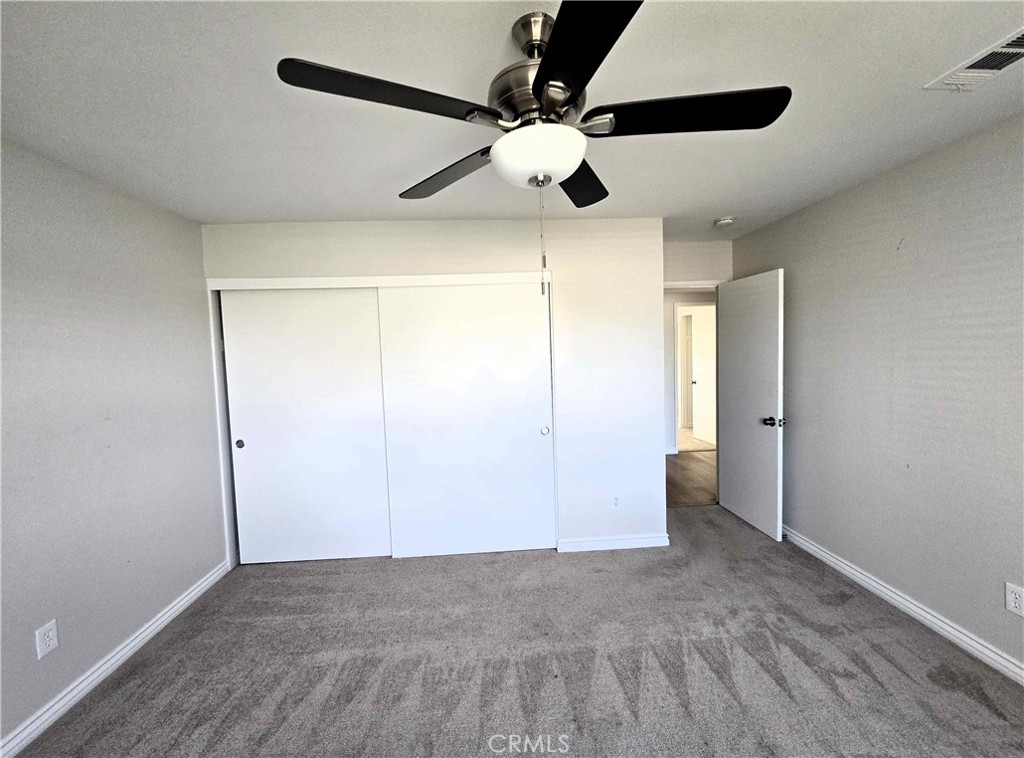 22909 Eyota Road Apple Valley, CA 92308 - Photo 11 of 18 a view of an empty room and a ceiling fan