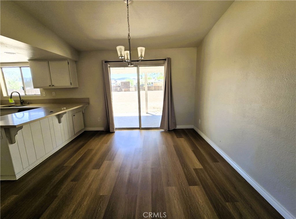 22909 Eyota Road Apple Valley, CA 92308 - Photo 4 of 18 a view of a kitchen with a sink wooden floor and a window