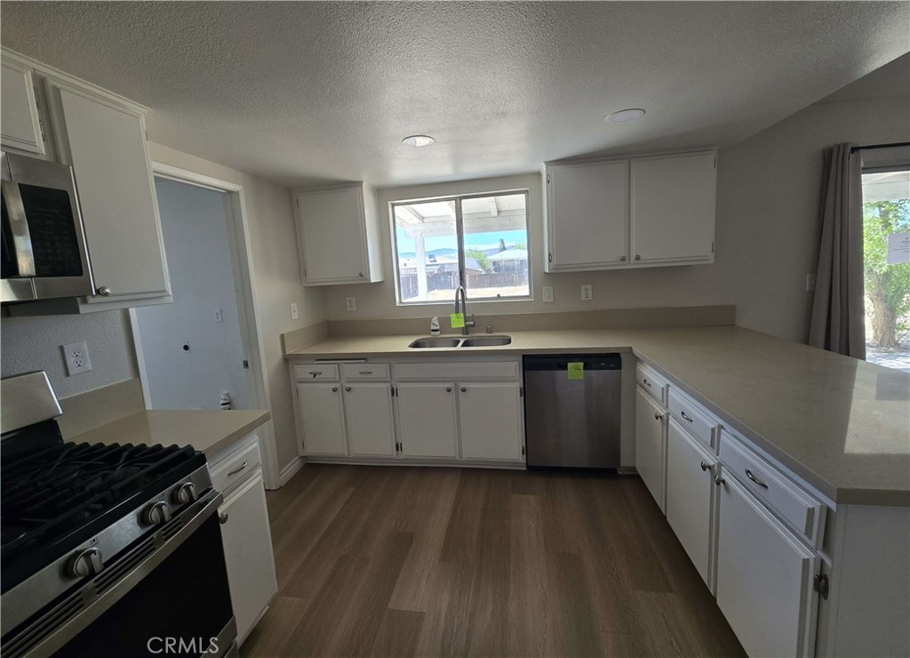 22909 Eyota Road Apple Valley, CA 92308 - Photo 5 of 18 a kitchen with a sink stove top oven and cabinets