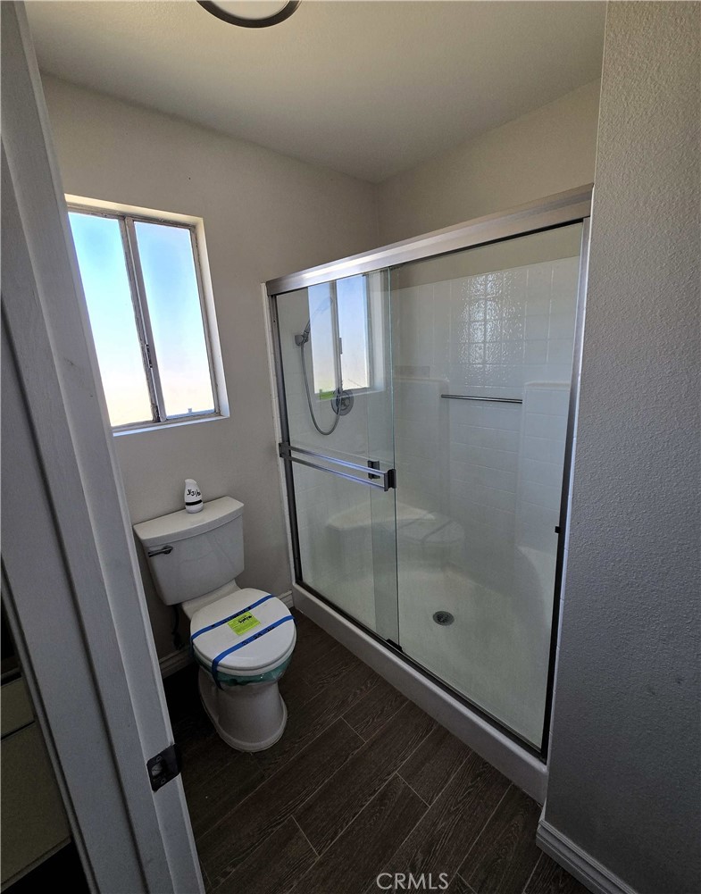 22909 Eyota Road Apple Valley, CA 92308 - Photo 10 of 18 a bathroom with a toilet and a shower