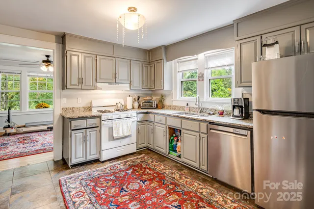 a kitchen with a white appliances cabinets and a window