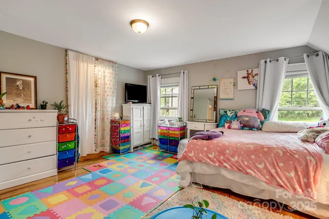 a bedroom that has a bed window and a dresser in it