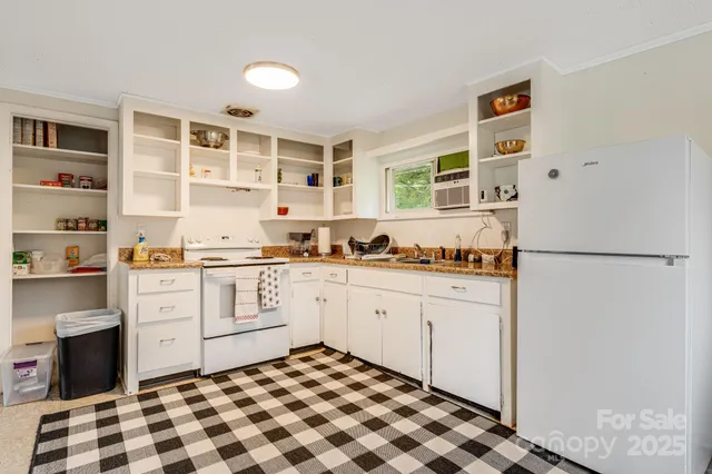 a kitchen with a refrigerator and white cabinets