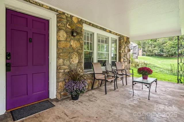 a view of a porch with chairs and a yard