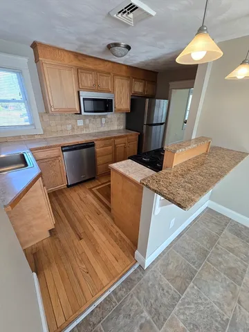 a kitchen with stainless steel appliances kitchen island granite countertop a stove a sink and a microwave