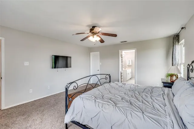 a bedroom with a bed a couch and a large window