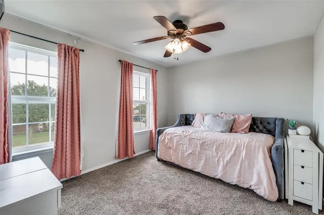 a bedroom with a bed and a large window