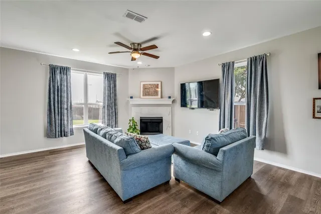 a living room with furniture a flat screen tv and a fireplace