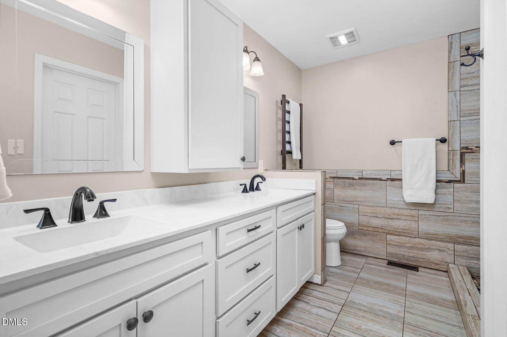 2141 McNair Road Tarboro, NC 27886 - Photo 19 of 55 a bathroom with a double vanity sink a mirror and a