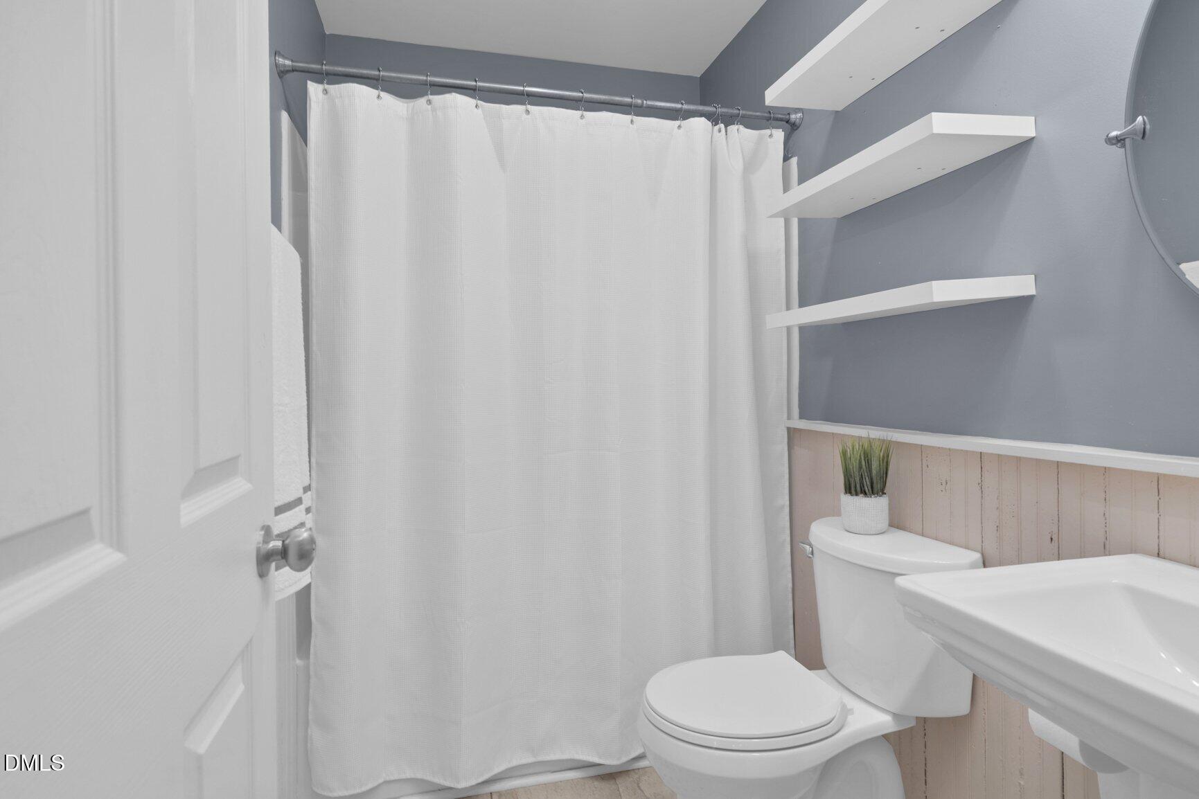 2141 McNair Road Tarboro, NC 27886 - Photo 25 of 55 a white toilet sitting next to a shower curtain