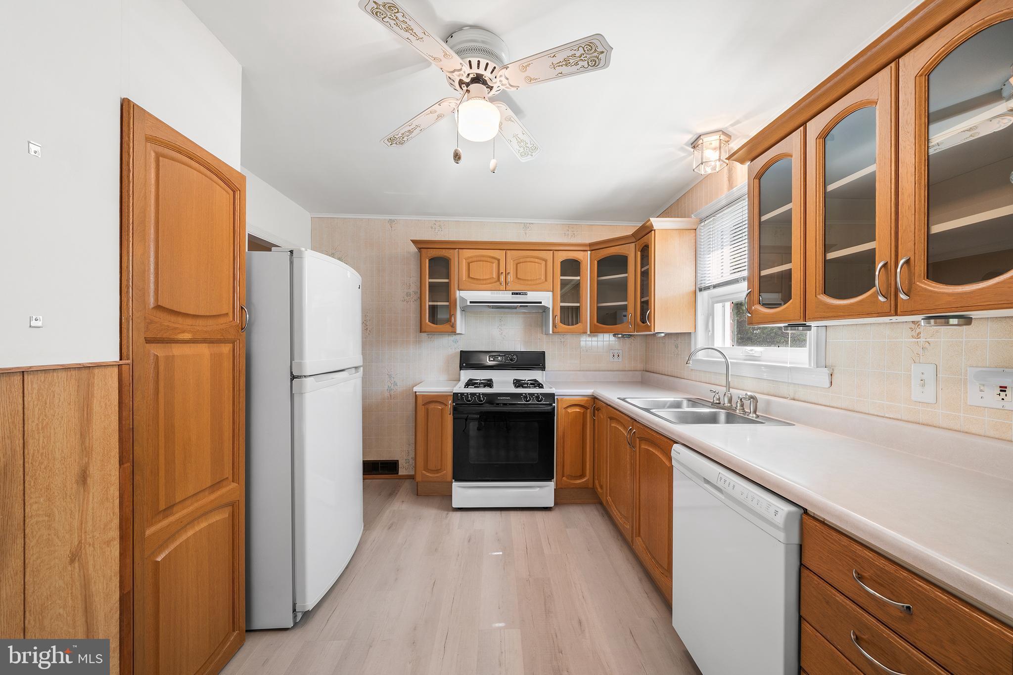 504 Lawrence Road Havertown, PA 19083 - Photo 14 of 20 a kitchen with stainless steel appliances granite countertop a refrigerator a sink dishwasher a stove and a dining table with wooden floor