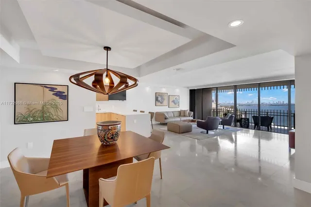 a living room with furniture a chandelier and a dining table