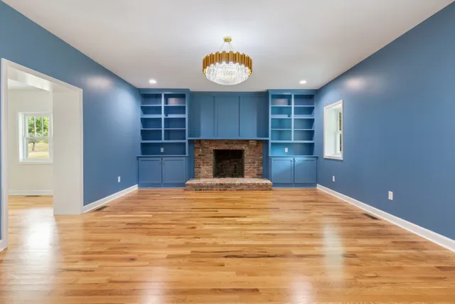 a view of an empty room with a fireplace and a window