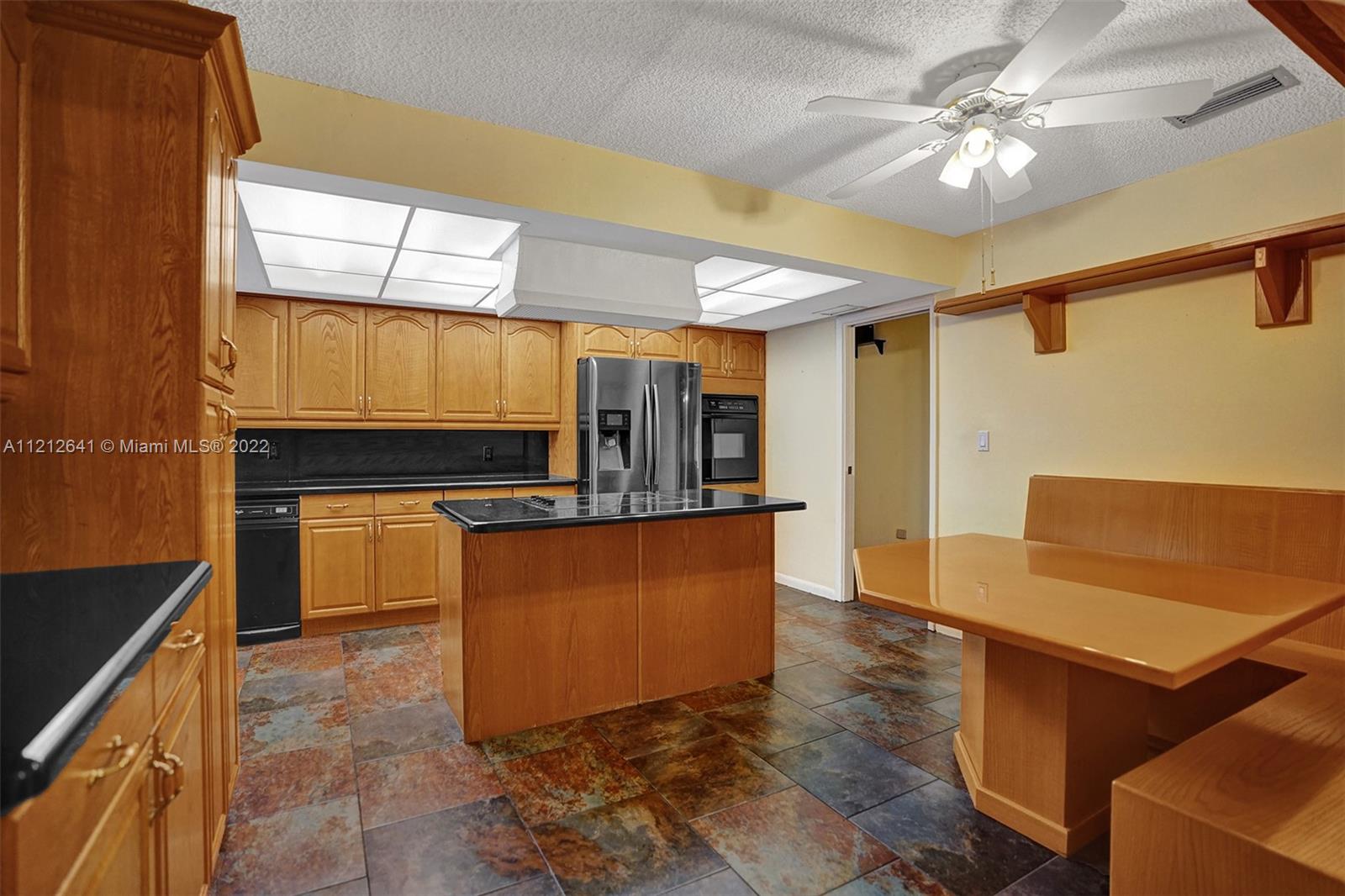 7420 Southwest 15th Street Plantation, FL 33317 - Photo 19 of 60 a kitchen with stainless steel appliances granite countertop a refrigerator a stove and a sink with wooden floor