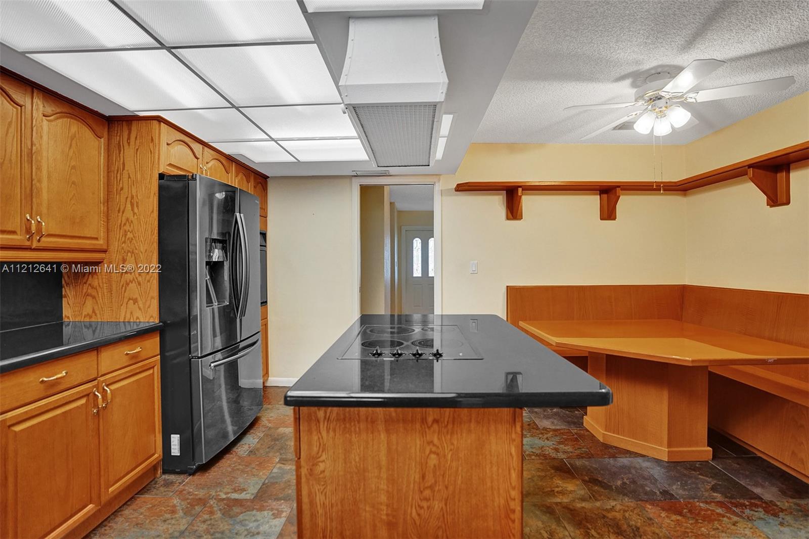7420 Southwest 15th Street Plantation, FL 33317 - Photo 21 of 60 a kitchen with stainless steel appliances granite countertop a refrigerator a sink dishwasher a stove and a dining table with wooden floor