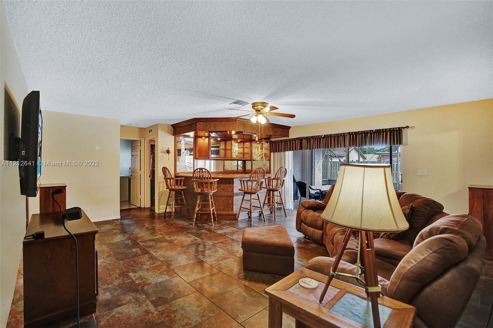 7420 Southwest 15th Street Plantation, FL 33317 - Photo 23 of 60 a living room with furniture a lamp and a flat screen tv