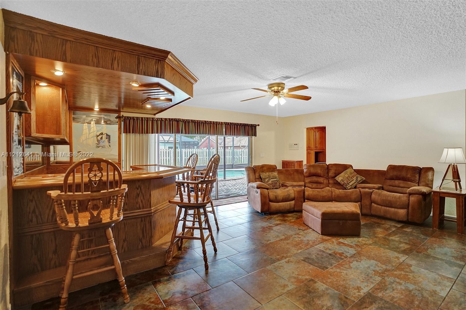 7420 Southwest 15th Street Plantation, FL 33317 - Photo 25 of 60 a living room with furniture a chandelier and kitchen view