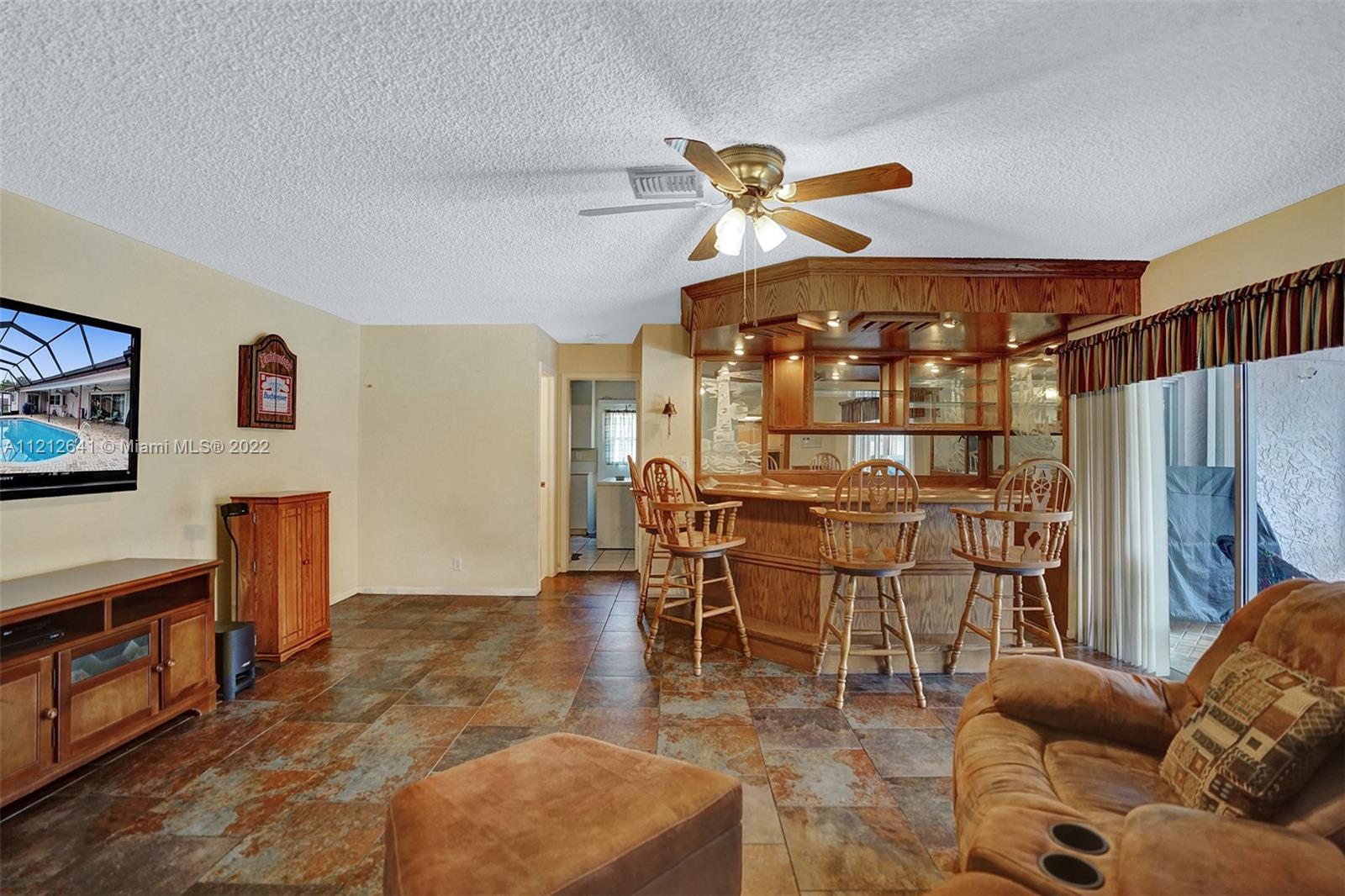 7420 Southwest 15th Street Plantation, FL 33317 - Photo 28 of 60 a living room with furniture a dining table and paintings on the wall